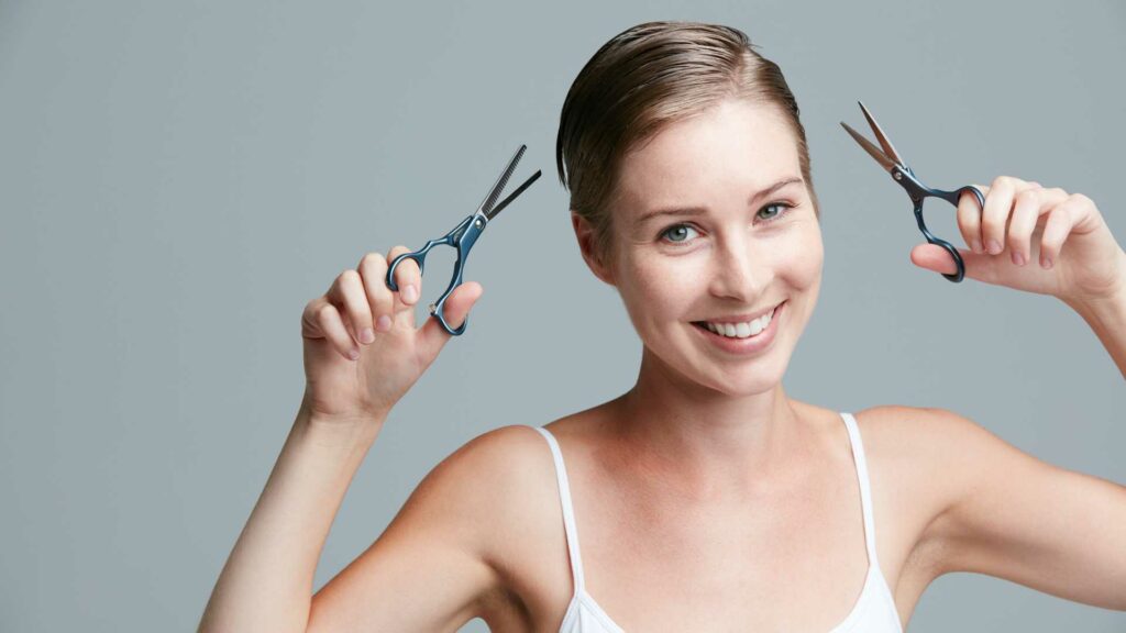 femme avec cheveux court et ciseaux dans les mains