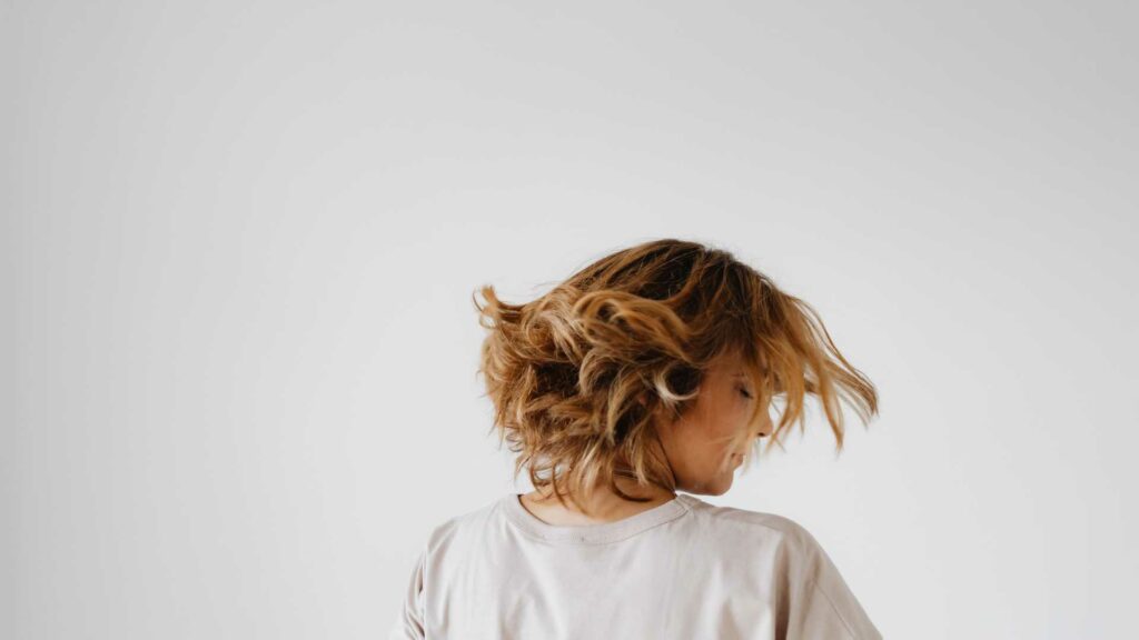 femme qui bouge ses cheveux devant fond blanc