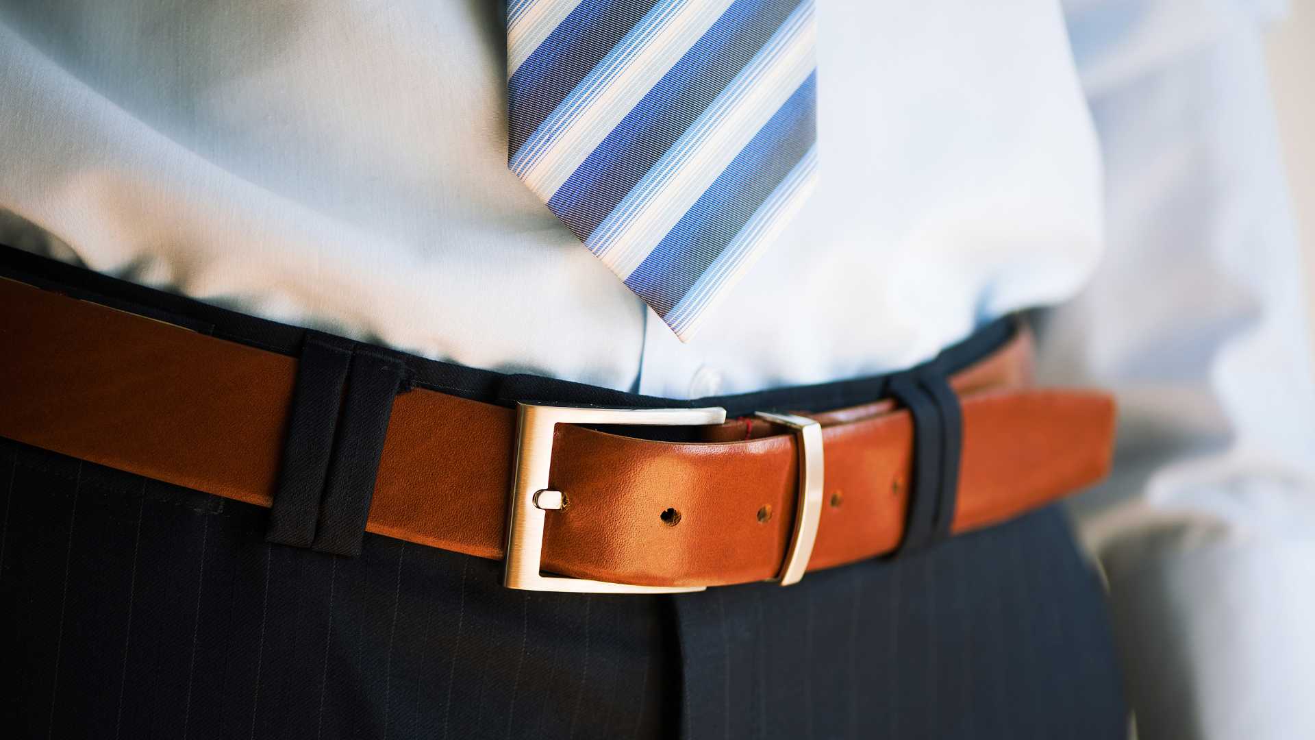 homme avec une ceinture en cuir marron