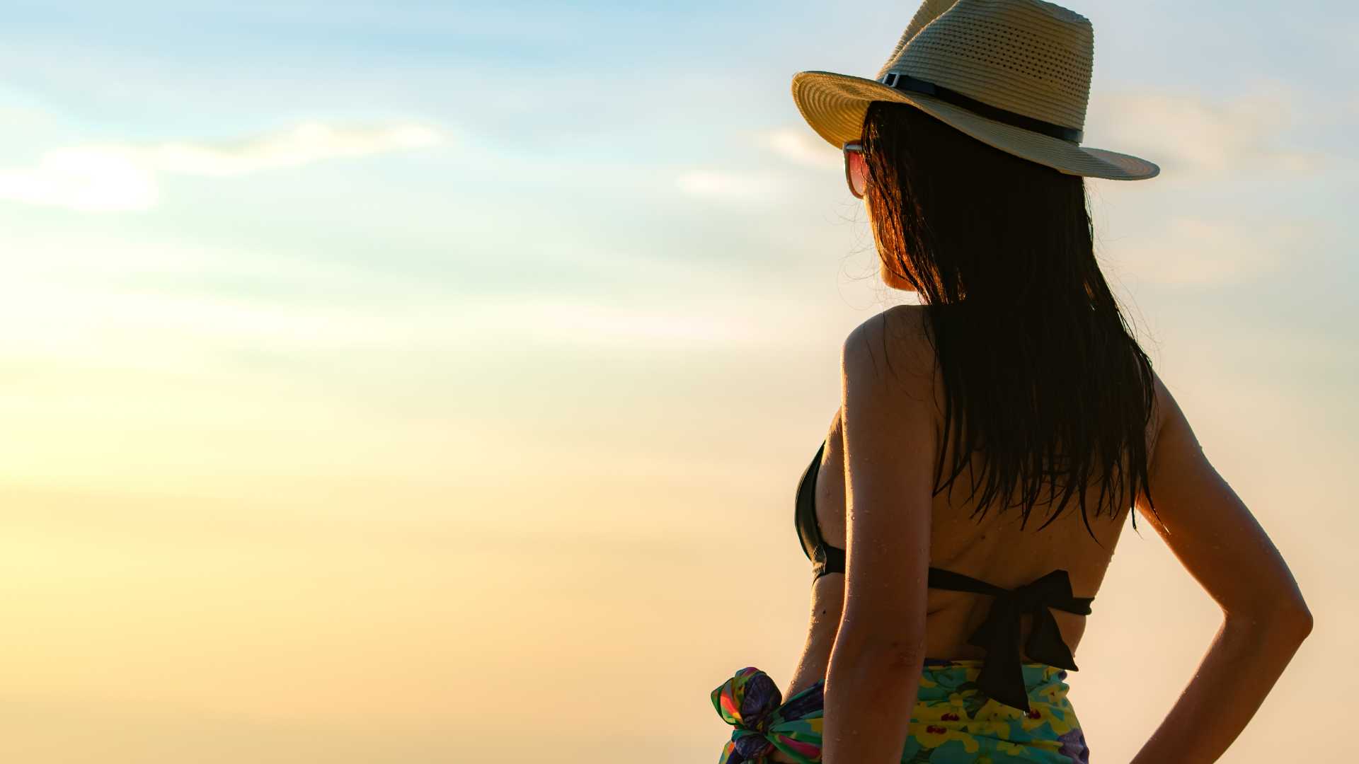 femme en maillot de bain avec un chapeau et un paréo